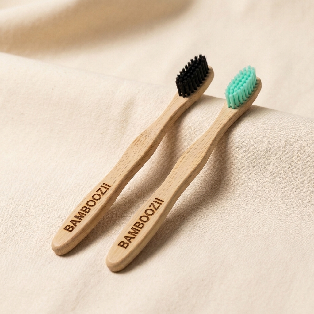 Bamboozii couple duo pack — two bamboo toothbrushes with charcoal and mint bristles on cream fabric