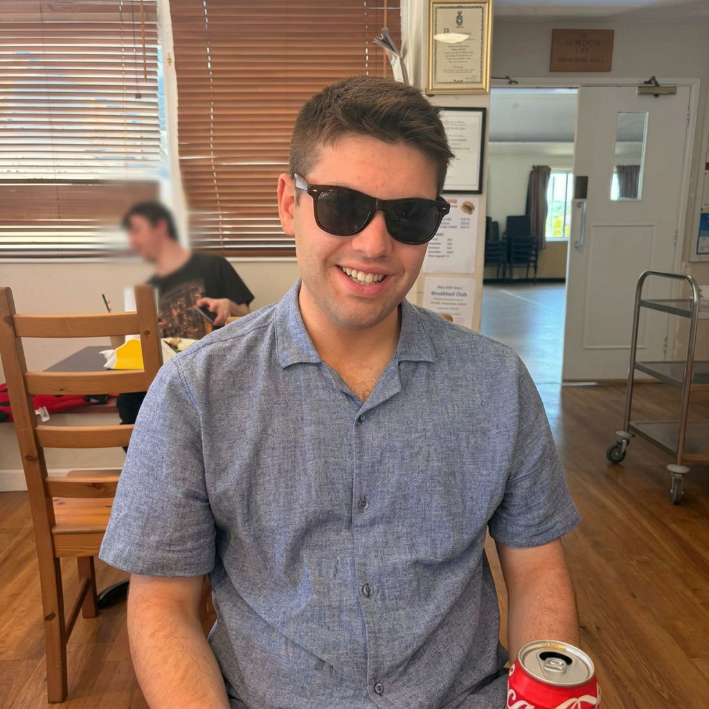 Someone we support enjoying a relaxed drink and a bite to eat at the community breakfast club.