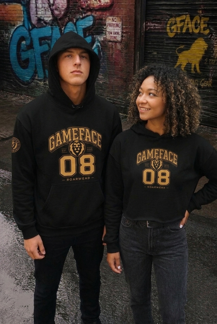 Shop GfaceGear Hoodies — woman in the Gameface 08 crop hoodie and man in the Gameface 08 oversized hoodie by a Gface graffiti wall — black and gold streetwear